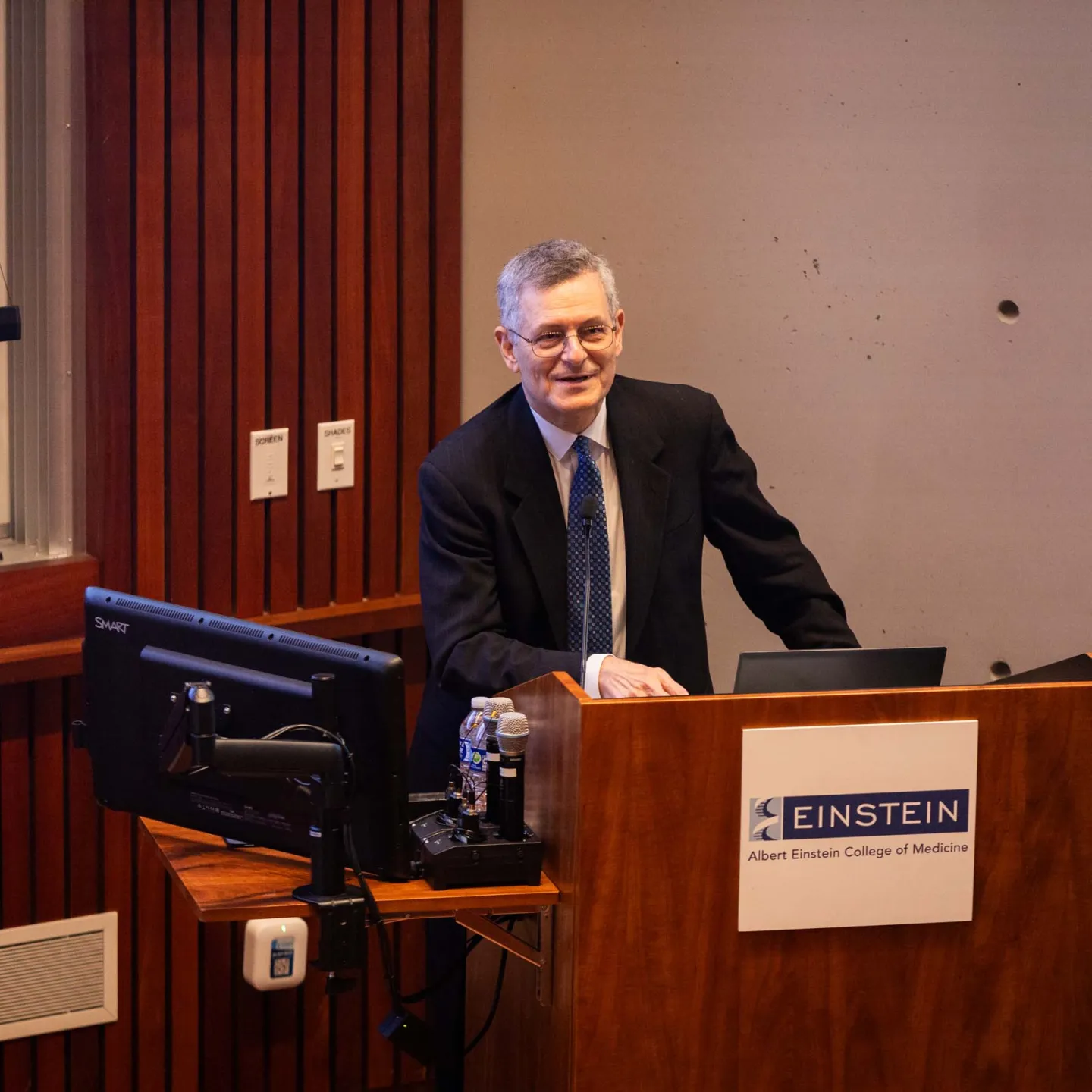 Dean Yaron Tomer at podium speaking in Lefrak Auditorium, closeup image