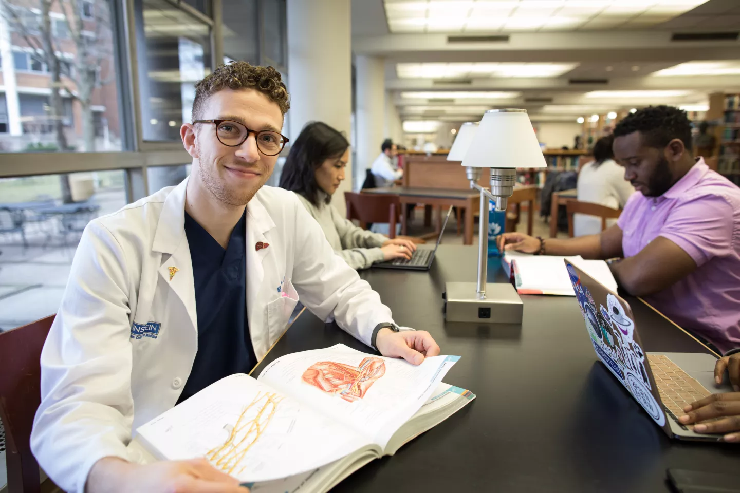 Student with open book in library