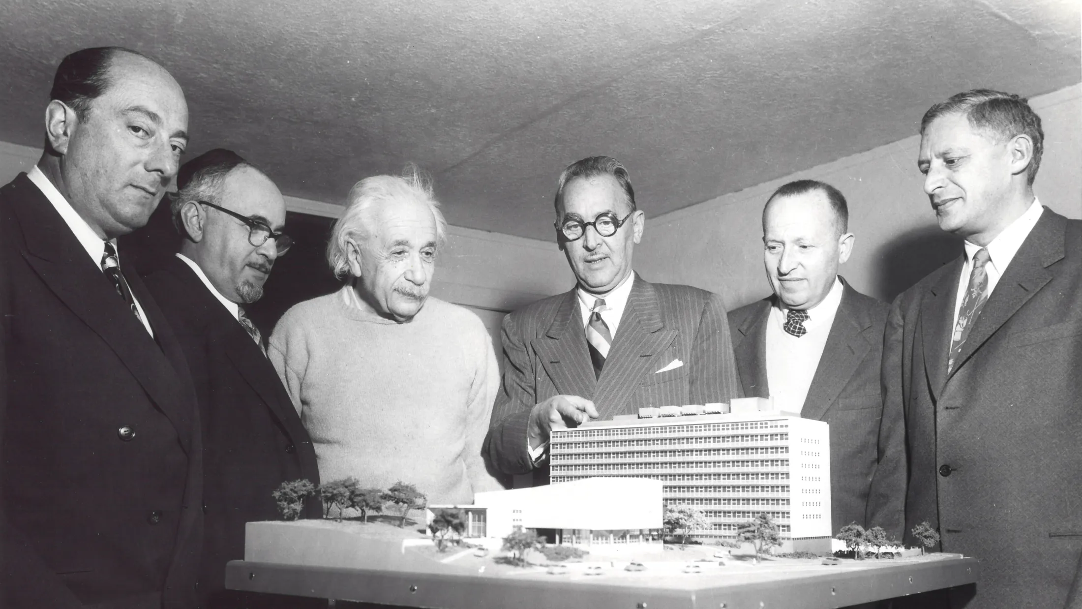 Professor Einstein viewing a model of the medical institution that now bears his name