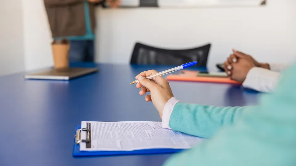 Businesswoman taking notes during a meeting in conference room