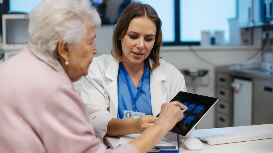 Doctor Explaining Result of MRI Scan of Brain to Senior Patient
